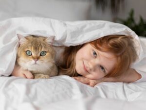 Девочка и кошка под одеялом